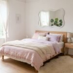 Danish pastel room ideas with soft pink bedding wavy mirror fluffy rug and cozy Scandinavian decor