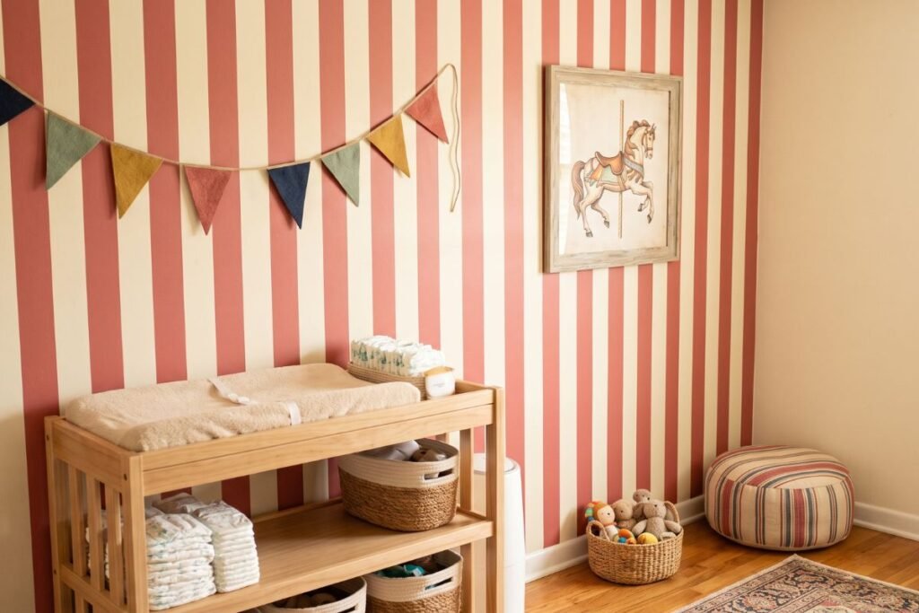 Vintage circus themed baby boy nursery with striped wall and pennant banner